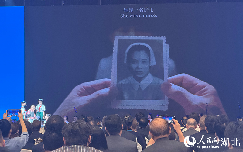 纪念活动现场，大屏幕展示黄欢笑的老照片。人民网记者 张沛摄