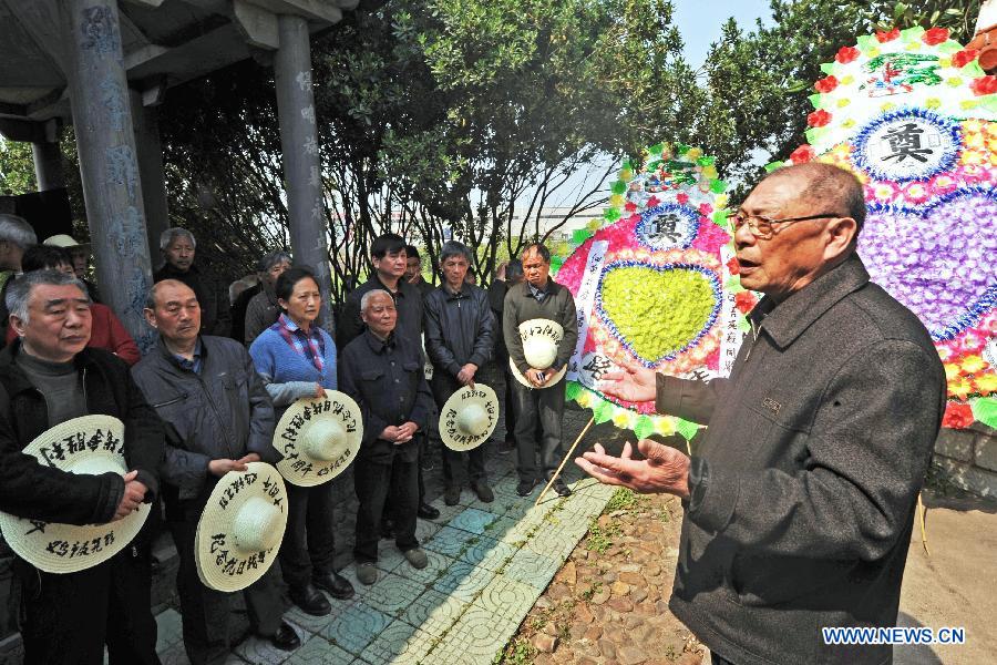 Wang Peigen, a member of a Chinese plaintiff group seeking compensation from the Japanese government for damages stemming from the use of germ warfare during Japan's aggression war on China, mourns victims with other people in Chongshan Village of Yiwu City, east China's Zhejiang Province, April 5, 2014. 