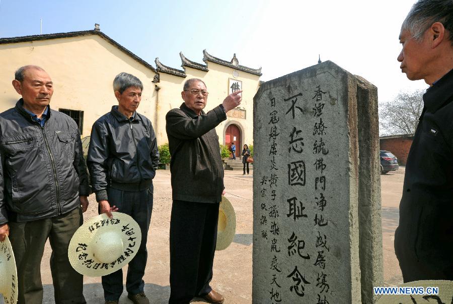 Members of a Chinese plaintiff group seeking compensation from the Japanese government for damages stemming from the use of germ warfare during Japan's aggression war on China, mourn victims in Chongshan Village of Yiwu City, east China's Zhejiang Province, April 5, 2014.