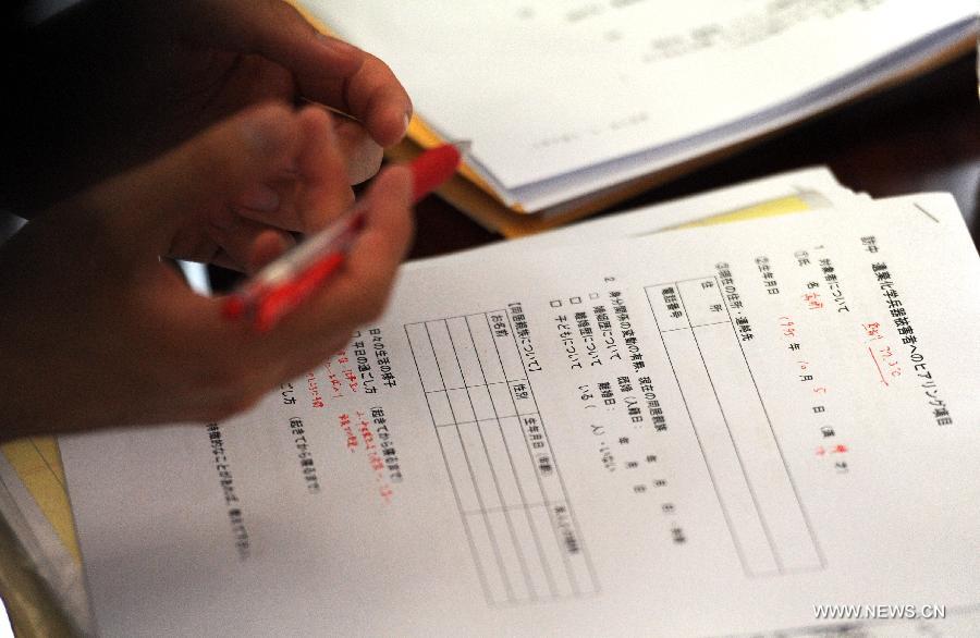 A Japanese lawyer notes down personal facts of victims of Japanese abandoned chemical weapons during a hearing event in Harbin, capital of northeast China's Heilongjiang Province, April 29, 2014. 