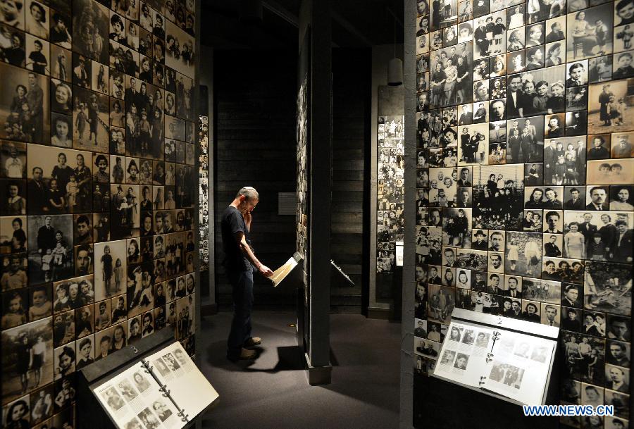 A visitor watches an exhibition on the hisitory of Holocaust and family photos of victims in the Museum of Jewish Heritage in New York City, the United States, on April 28, 2014. An event named 'A Living Memorial to the Holocaust' is held here for commemoration of Holocaust Remembrance Day on Monday. Holocaust survivors from Poland, Germany, and Belgium who are now living in New York met with more than 300 students and visitorsg here and shared with them what they had been thourgh during the Holocaust. (Xinhua/Wang Lei) 