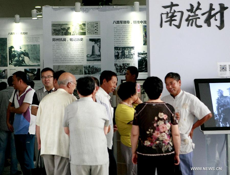 Visitors watch exhibits at an exhibition about the Anti-Japanese War in Zhengzhou, capital of central China's Henan Province, July 16, 2015. 
