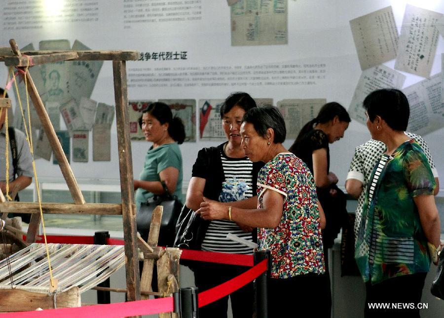 Visitors watch exhibits at an exhibition about the Anti-Japanese War in Zhengzhou, capital of central China's Henan Province, July 16, 2015. 