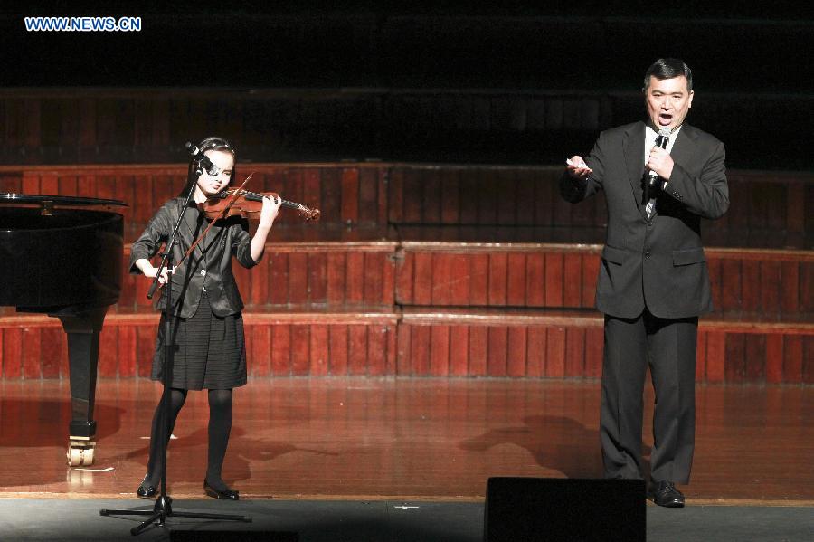 An actor recites poems accompanied with violin during an evening concert to commemorate the 70th anniversary of the victory in the Chinese People's War of Resistance against Japanese Aggression and the victory of World's Anti-Fascist War, in town hall of Sydney, Australia, July 26, 2015.