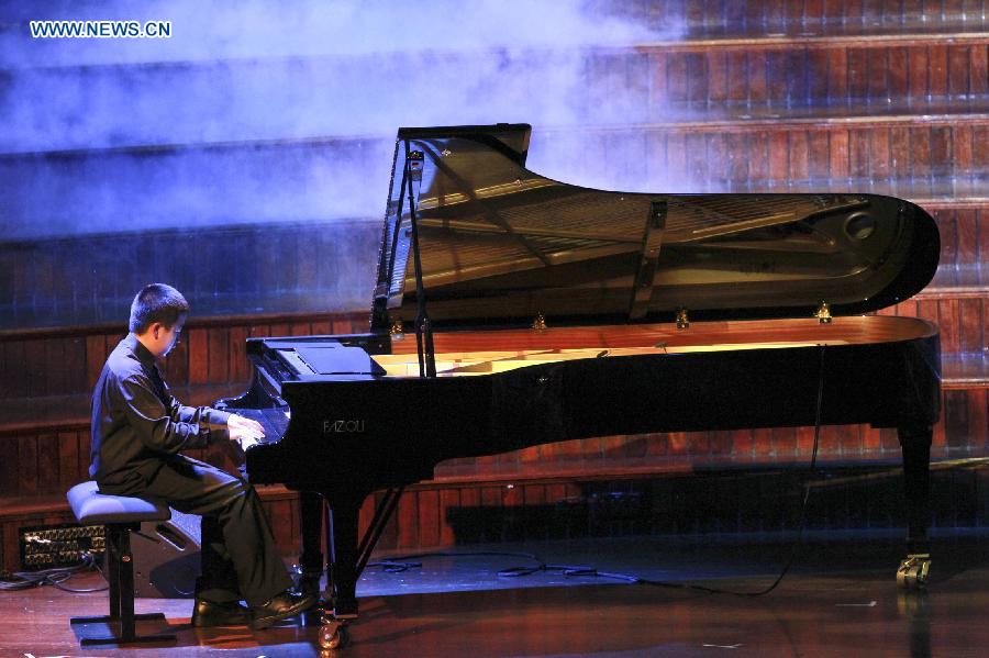 A boy plays the piano during an evening concert to commemorate the 70th anniversary of the victory in the Chinese People's War of Resistance against Japanese Aggression and the victory of World's Anti-Fascist War, in town hall of Sydney, Australia, July 26, 2015. 