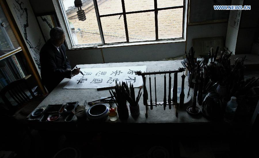 Lu Caiwen practises calligraphy at his home in Tengchong, southwest China's Yunnan Province, July 20, 2015. 