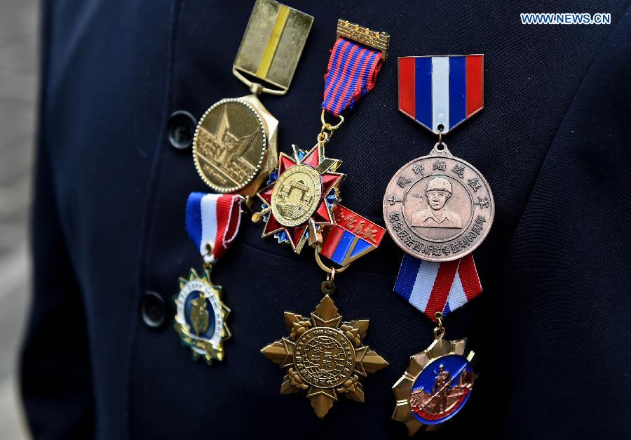 Photo taken on July 21, 2015 shows badges on the clothes of Lu Caiwen in Tengchong, southwest China's Yunnan Province.