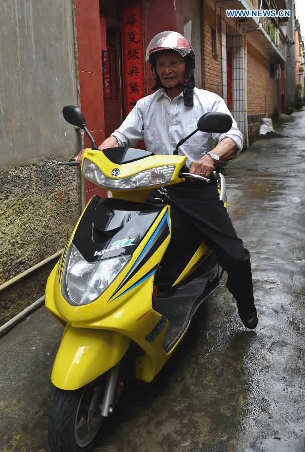 Lu Caiwen rides an electric bicycle in Tengchong, southwest China's Yunnan Province, July 20, 2015.