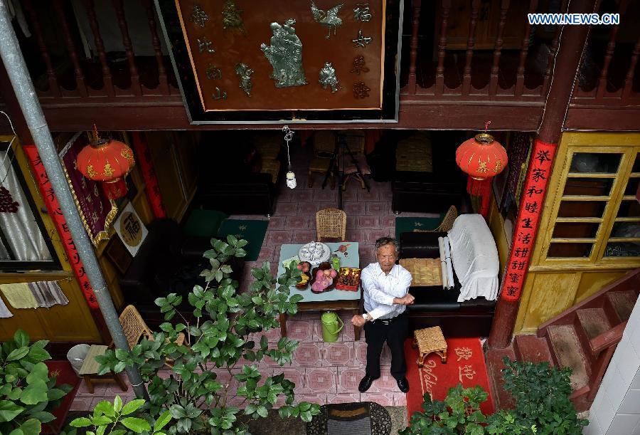 Lu Caiwen does physical exerciese at home in Tengchong, southwest China's Yunnan Province, July 20, 2015.