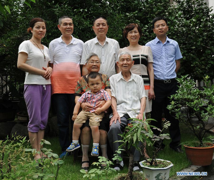 Wang Mingcai (R Front) poses with his family for a group photo at home in Yiwu, east China's Zhejiang Province, July 26, 2015. 