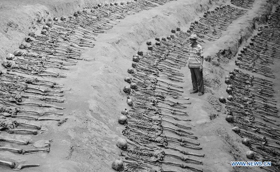 File photo taken on Aug. 28, 2014 shows Sun Yuanxin, who is a surviving forced miner working for Japan during the World War II, looking at the remains of forced miners at a museum of Liaoyuan miners' tomb during Japanese occupation in Liaoyuan, northeast China's Jilin Province. Japan invaded northeast China in 1931 and conducted a full-scale invasion in 1937. By the end of World War II, millions of Chinese forced laborers had been enslaved by Japanese invaders to toil under harsh conditions at mines and factories in northeast China and Japan. Those laborers were under close watch and suffered inhumane treatment. Many of them died from malnutrition, illness, physical abuse and plain murder. (Xinhua/Wang Haofei) 