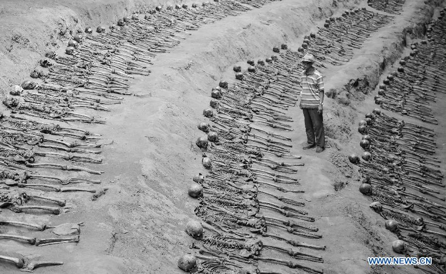 File photo taken on Aug. 28, 2014 shows Sun Yuanxin, who is a surviving forced miner working for Japan during the World War II, looking at the remains of forced miners at a museum of Liaoyuan miners' tomb during Japanese occupation in Liaoyuan, northeast China's Jilin Province. Japan invaded northeast China in 1931 and conducted a full-scale invasion in 1937. By the end of World War II, millions of Chinese forced laborers had been enslaved by Japanese invaders to toil under harsh conditions at mines and factories in northeast China and Japan. Those laborers were under close watch and suffered inhumane treatment. Many of them died from malnutrition, illness, physical abuse and plain murder. (Xinhua/Wang Haofei) 