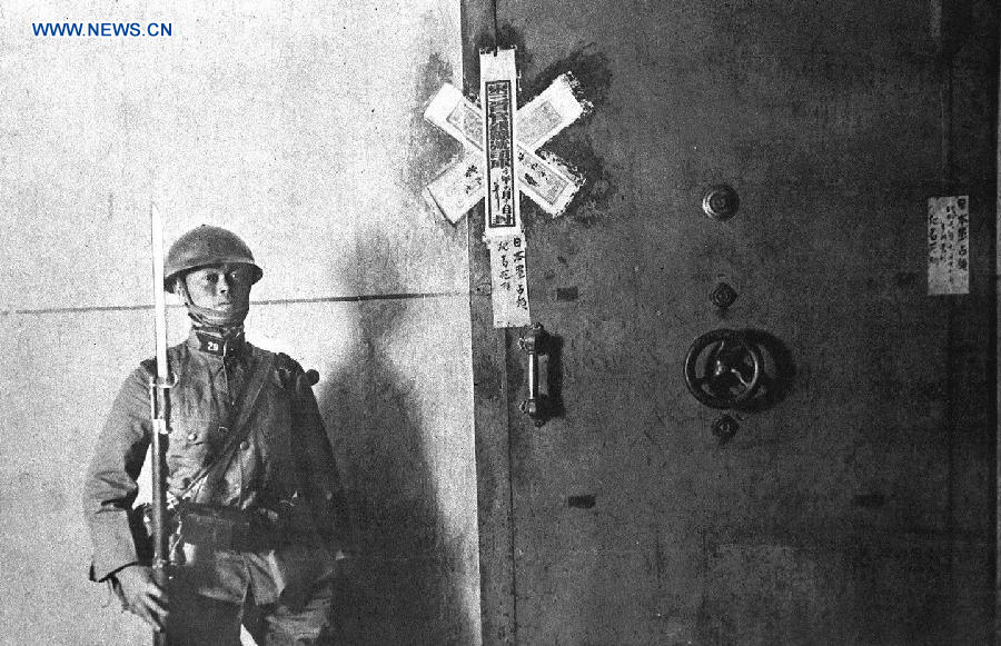 File photo shows a Japanese soldier guards the door of coffers, with notes on it saying 'occupied by Japanese army', at the central bank of three northeast provinces of China in 1931.