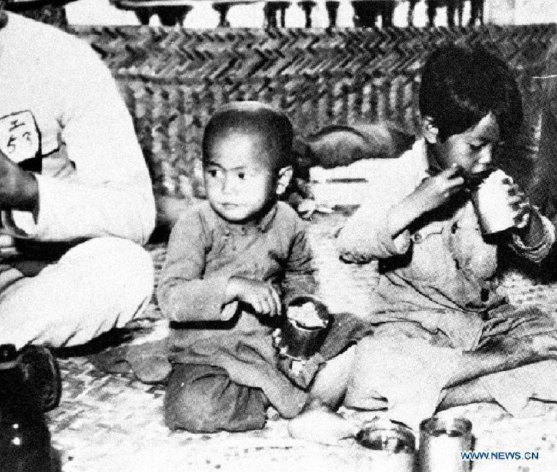 Undated file photo shows Chinese children eating leftover in a prison camp in China. In the wartime of Japanese aggression to China during World War II, around 2.2 million Chinese children were killed or injured by Japanese invaders.