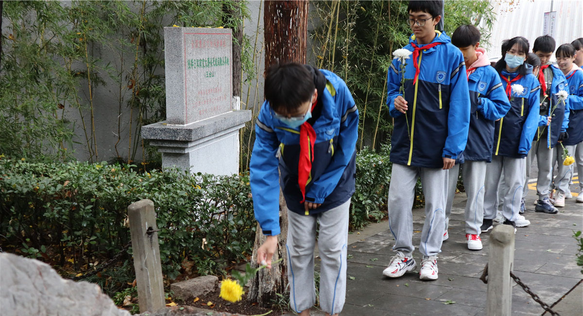 学生们在侵华日军南京大屠杀遇难同胞五台山丛葬地纪念碑前献花。
